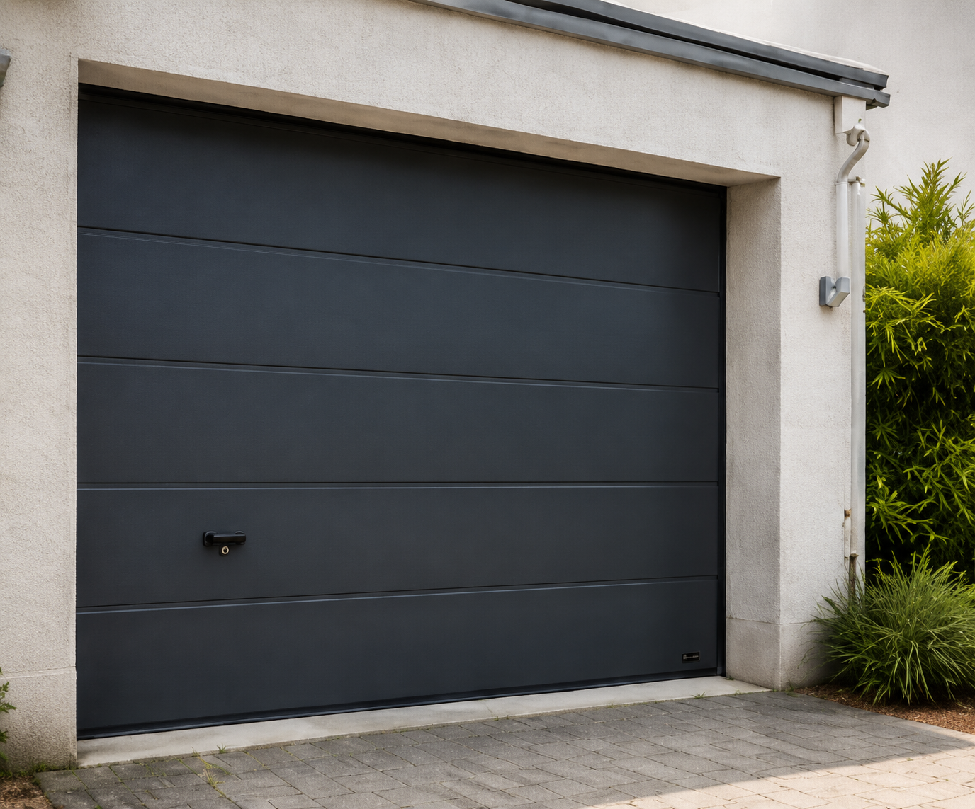 Porte de garage sectionnelle gris anthracite intégrée à une maison moderne